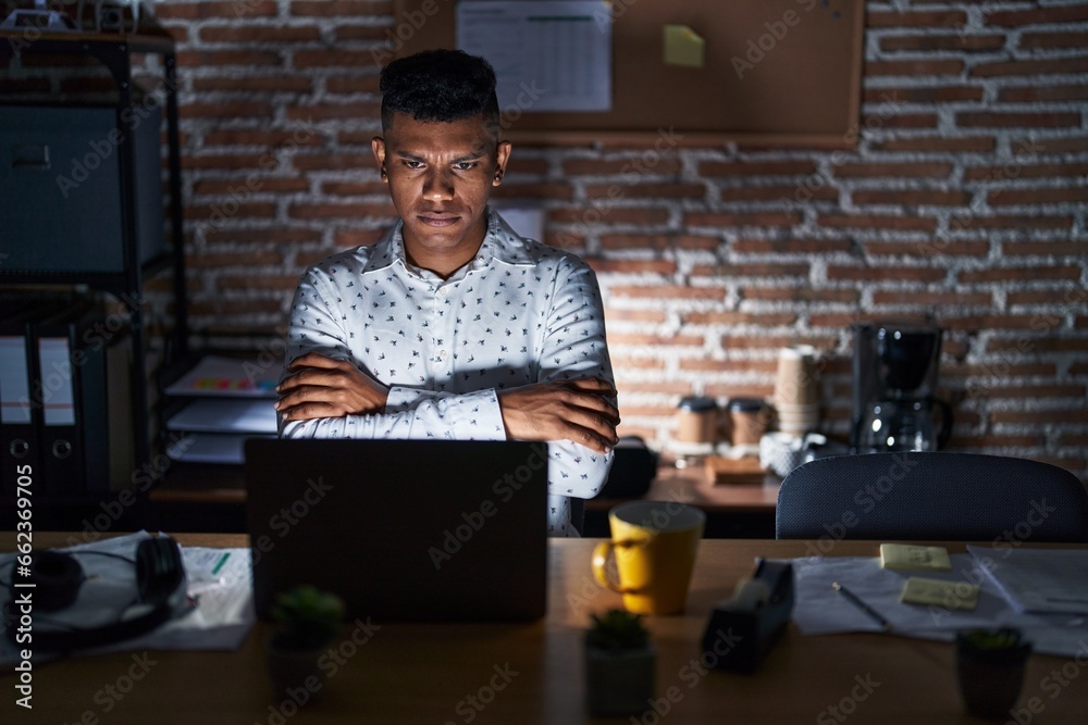 © Krakenimages.com - Young hispanic man working at the office at night skeptic and nervous, disapproving expression on face with crossed arms. negative person. © Krakenimages.com - Young hispanic man working at the office at night skeptic and nervous, disapproving expression on face with crossed arms. negative person.