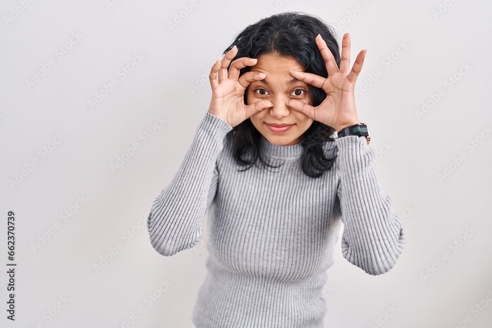 Hispanic woman with dark hair standing over isolated background trying to open eyes with fingers, sleepy and tired for morning fatigue Hispanic woman with dark hair standing over isolated background trying to open eyes with fingers, sleepy and tired for morning fatigue