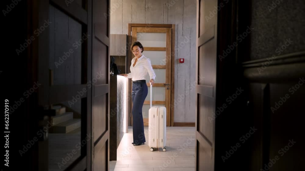 Business woman walking with luggage at the hotel into reception hall Business woman walking with luggage at the hotel into reception hall
