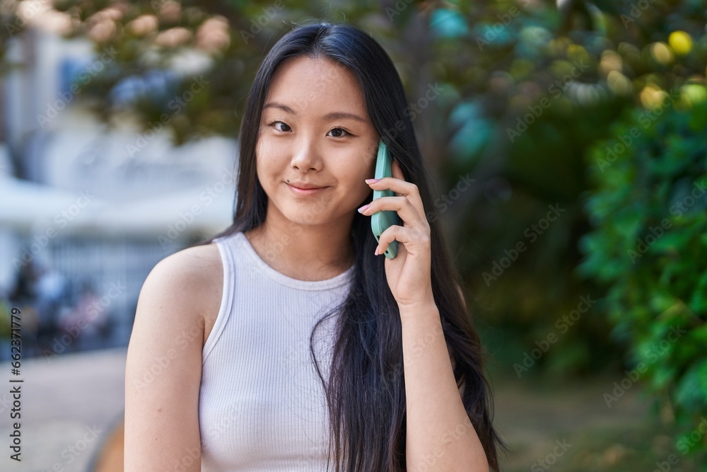 Young chinese woman smiling confident talking on the smartphone at park Young chinese woman smiling confident talking on the smartphone at park