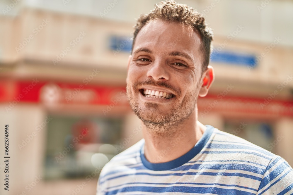 Obraz premium Young hispanic man smiling confident standing at street