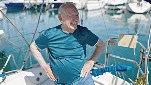 Senior grey-haired man smiling confident standing at boat