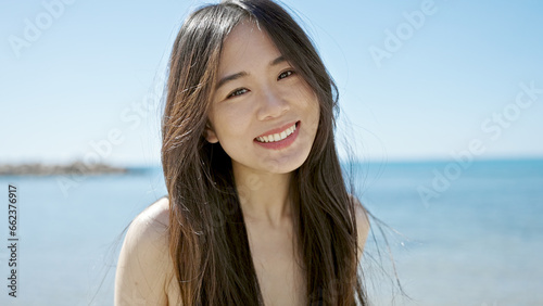 Fotografie Young chinese woman tourist smiling confident wearing swimsuit at seaside