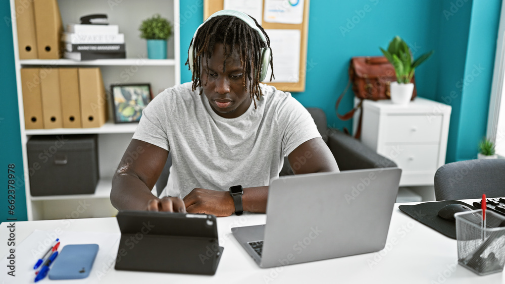 African american man business worker using touchpad and laptop working at the office