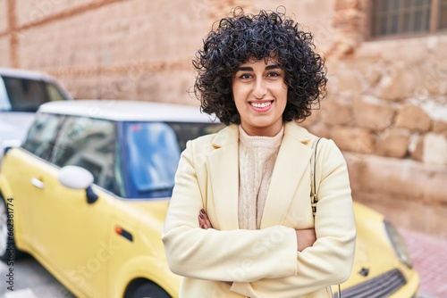 Young middle east woman excutive smiling confident standing with arms crossed gesture at street