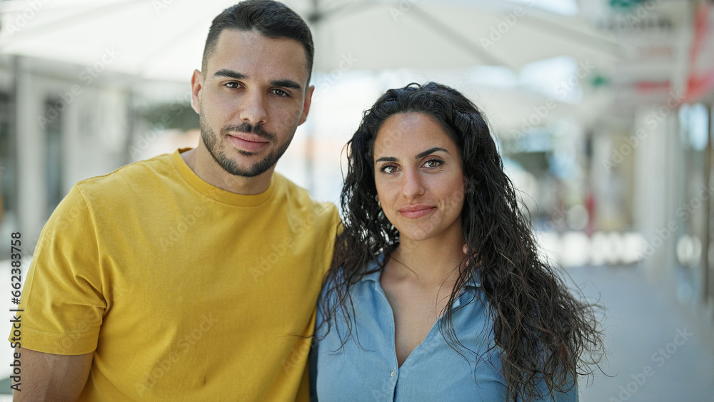 Man and woman couple standing together with relaxed face at street