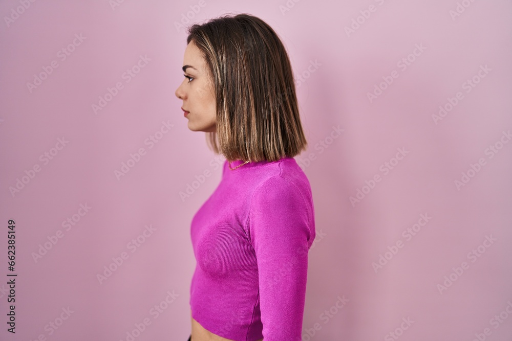 Hispanic woman standing over pink background looking to side, relax profile pose with natural face and confident smile. Hispanic woman standing over pink background looking to side, relax profile pose with natural face and confident smile.