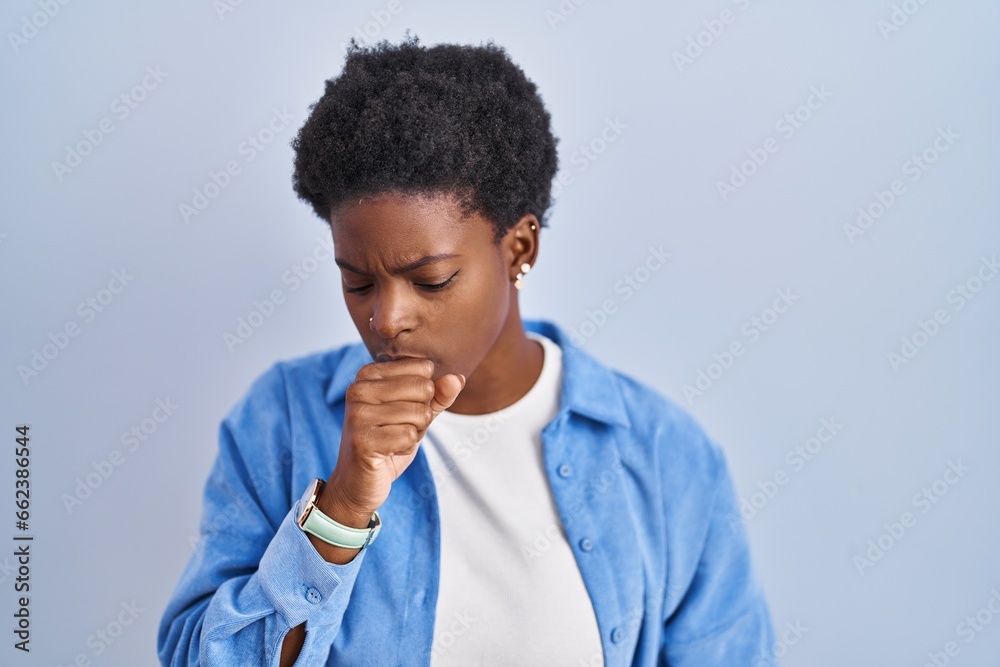 African american woman standing over blue background feeling unwell and coughing as symptom for cold or bronchitis. health care concept. African american woman standing over blue background feeling unwell and coughing as symptom for cold or bronchitis. health care concept.