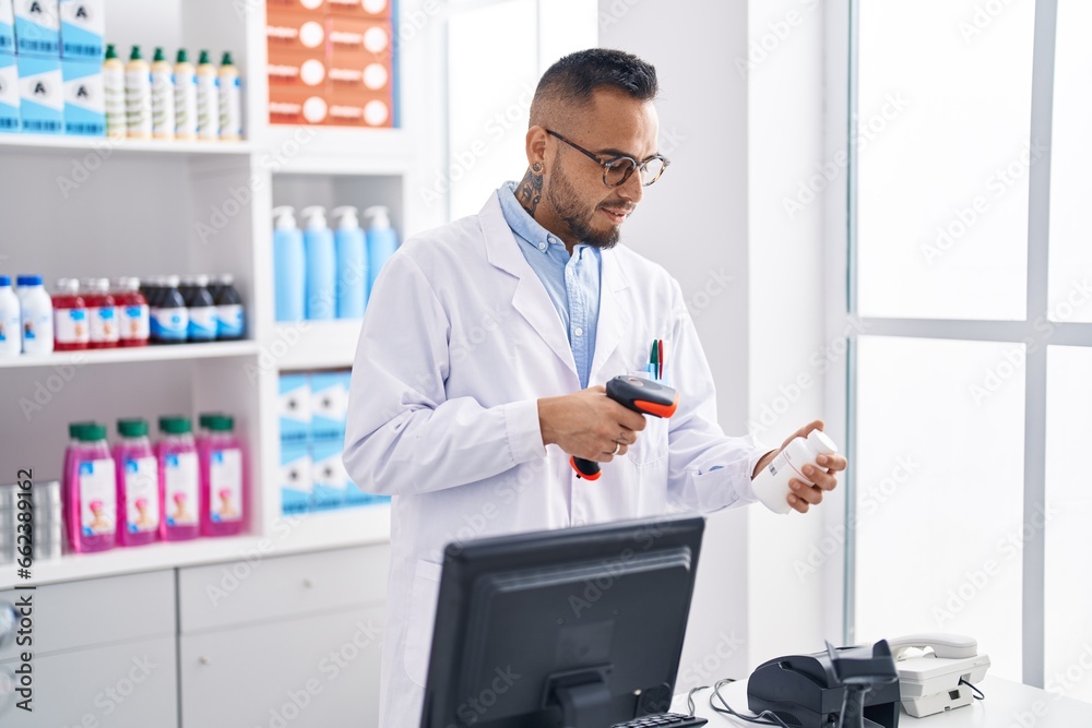 Young hispanic man pharmacist scanning pills bottle at pharmacy