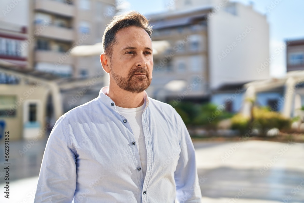 Young caucasian man looking to the side with serious expression at street Young caucasian man looking to the side with serious expression at street