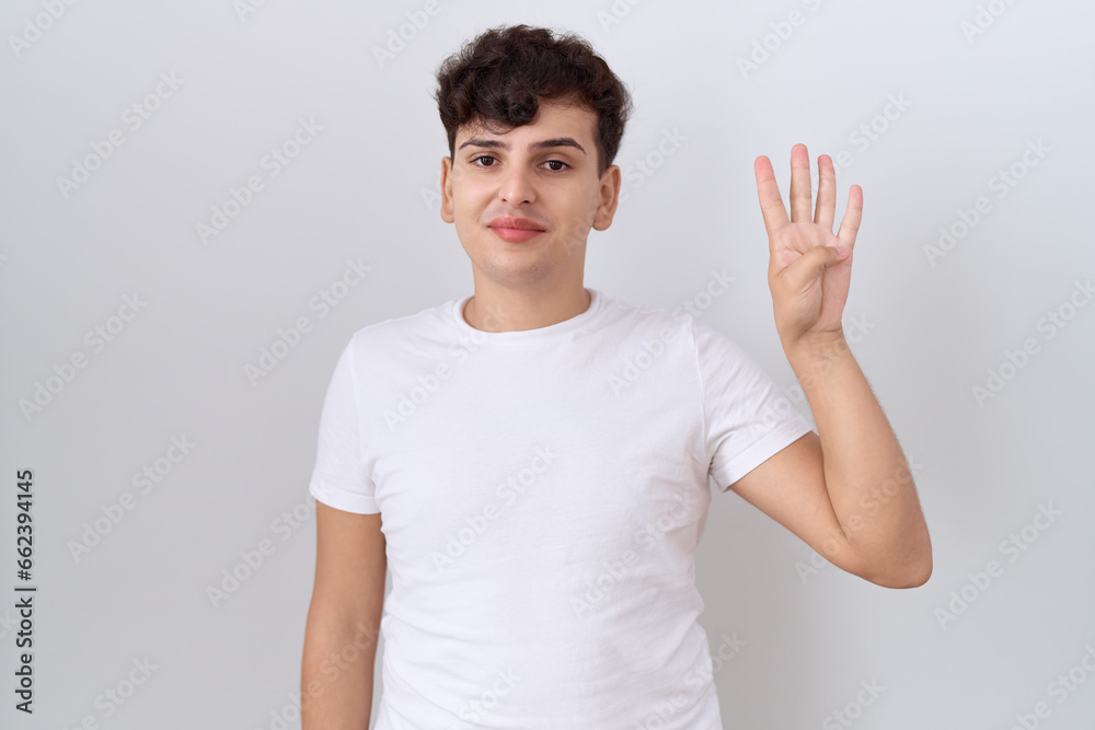 Young non binary man wearing casual white t shirt showing and pointing up with fingers number four while smiling confident and happy. Young non binary man wearing casual white t shirt showing and pointing up with fingers number four while smiling confident and happy.