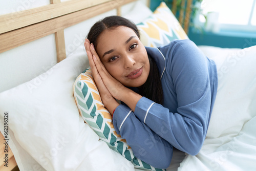 Young arab woman smiling confident lying on bed at bedroom