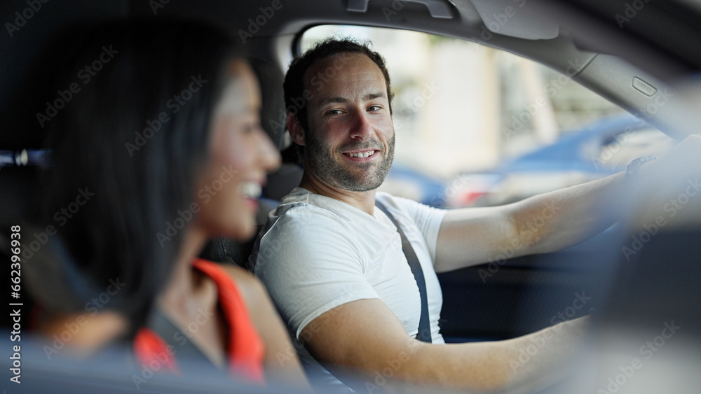 Beautiful couple smiling confident driving car at street