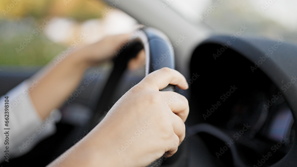 Young beautiful hispanic woman driving a car on the road