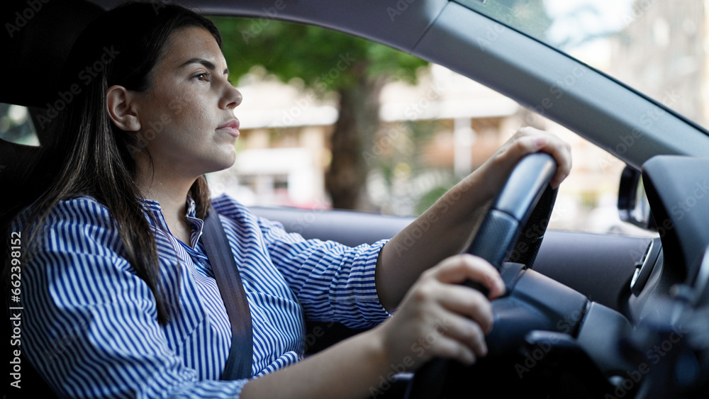 Young beautiful hispanic woman driving a car on the road Young beautiful hispanic woman driving a car on the road