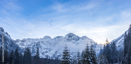 "Crisp winter morning highlighting a snowy mountain peak in grandeur"