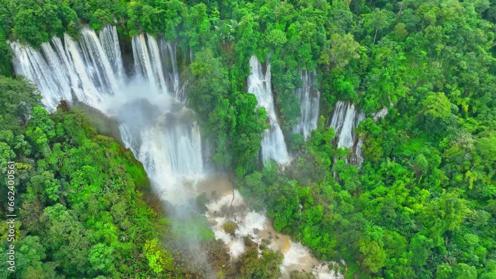 A hidden gem in the heart of a lush tropical rainforest, this colossal waterfall cascades gracefully through the dense emerald canopy. Lush Wild Woods: Earth's Green Jewel. Drone view. Thailand. 4K.
A hidden gem in the heart of a lush tropical rainforest, this colossal waterfall cascades gracefully through the dense emerald canopy. Lush Wild Woods: Earth's Green Jewel. Drone view. Thailand. 4K.
