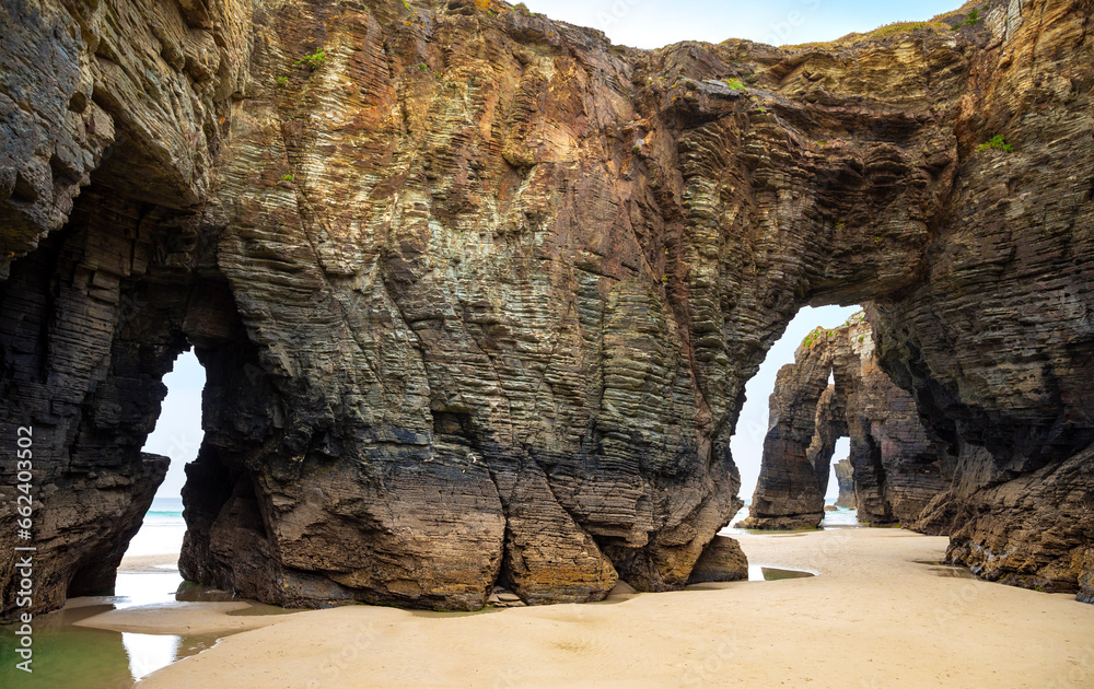 Natural rock arches Cathedrals beach, Playa de las Catedrales at Ribadeo, Galicia, Spain. Famous beach in Northern Spain Atlantic. Natural rock arch on Cathedrals beach in low tide