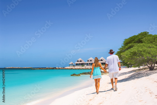 Fototapeta Naklejka Na Ścianę i Meble -  A couple on a beach. Man and woman walking on the coast of Tres Trapi Aruba. Peaceful blue skies and turquoise waters in Aruba.