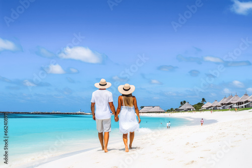 Fototapeta Naklejka Na Ścianę i Meble -  A couple on a beach. Man and woman walking on the coast of Tres Trapi Aruba. Peaceful blue skies and turquoise waters in Aruba.