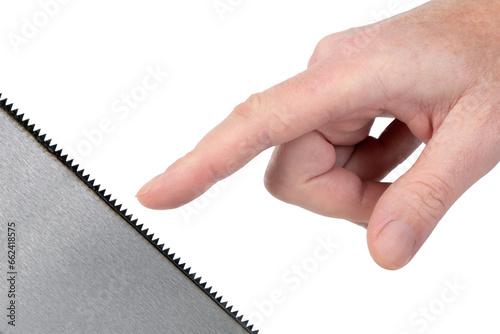 Close-up of a man stretching his finger to try the sharpness of the saw. Conceptual image.