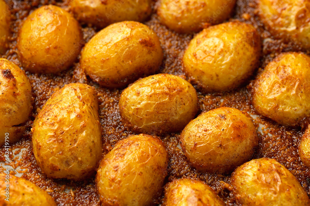 Parmesan crusted baby new potatoes on a baking tray Parmesan crusted baby new potatoes on a baking tray