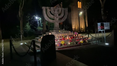 Menorah monument in Babiny Yar in Kyiv, night time Holocaust Remembrance Day. Honoring the victims of the Second World War. Candle fire, memory of the shot dead. High quality 4k footage