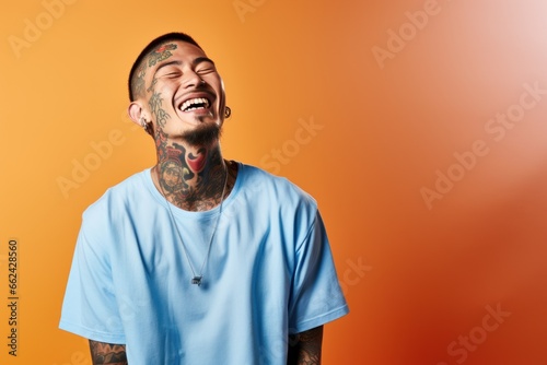 Young man with neck and face tattoos smiling happy face laughing