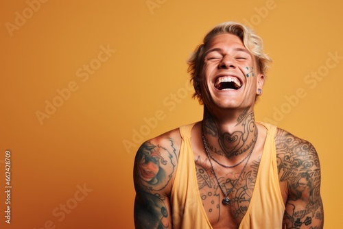 Young man with neck and face tattoos smiling happy face laughing
