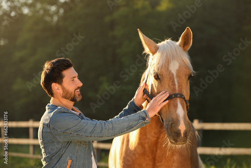 Man with adorable horse outdoors. Lovely domesticated pet