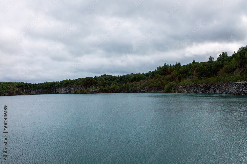 Cold mountain lake with clean transparent water, Northern quarry pond