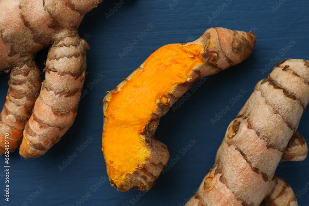 Raw turmeric roots on blue wooden table, flat lay Raw turmeric roots on blue wooden table, flat lay