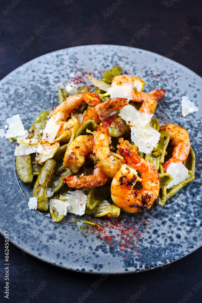 Traditional fried king prawns with Italian foglie di olivo pasta and parmesan cheese served as close-up on a design plate with text space Traditional fried king prawns with Italian foglie di olivo pasta and parmesan cheese served as close-up on a design plate with text space