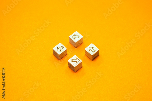 矢印をウッドキューブにマークし左回りに並べたオレンジ色の背景の正面