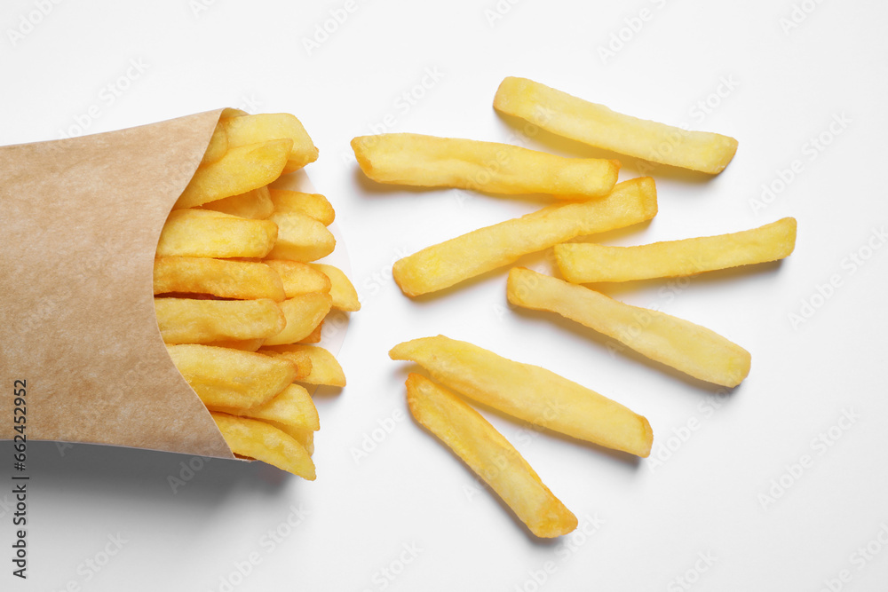 Paper cup with French fries on white table, flat lay Paper cup with French fries on white table, flat lay