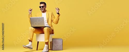 Joyful surprised man sitting with laptop on his lap in winning pose isolated on flat pastel background with copy space. Online giveaway banner template.  photo