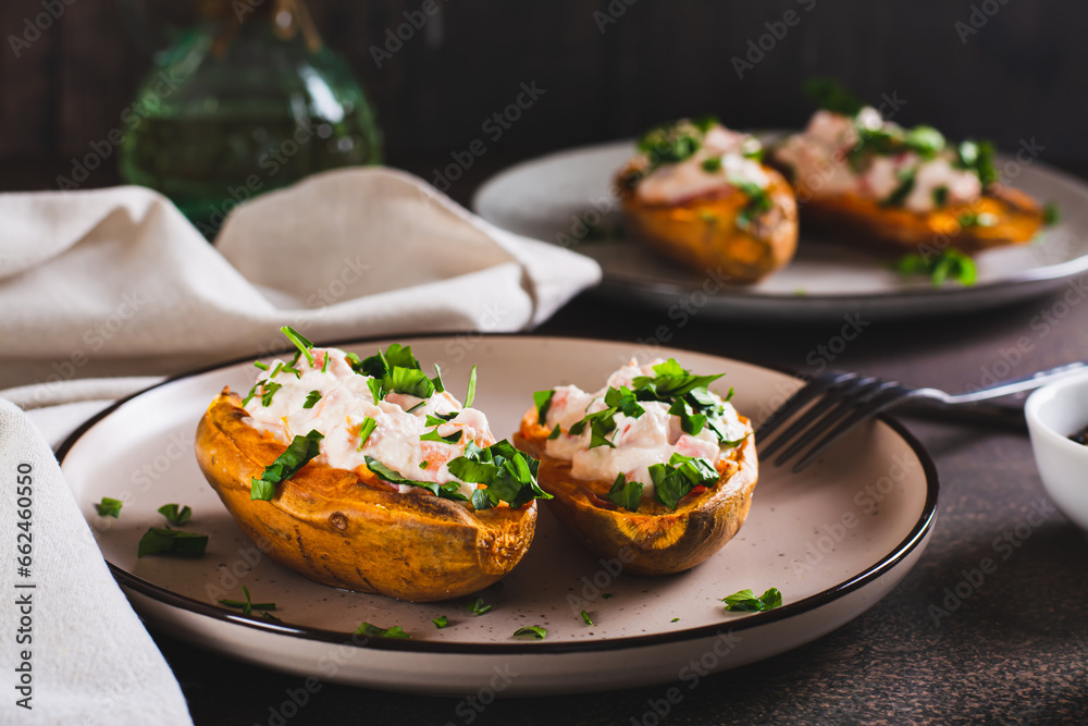 Baked sweet potato stuffed with ricotta, tomatoes and herbs on a plate