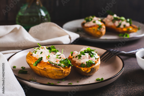 Baked sweet potato stuffed with ricotta, tomatoes and herbs on a plate