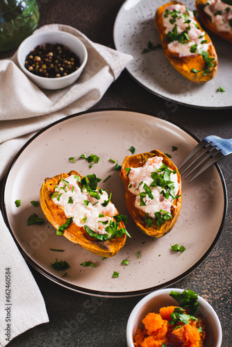 Baked sweet potato filled with ricotta, tomato and parsley on a plate vertical view