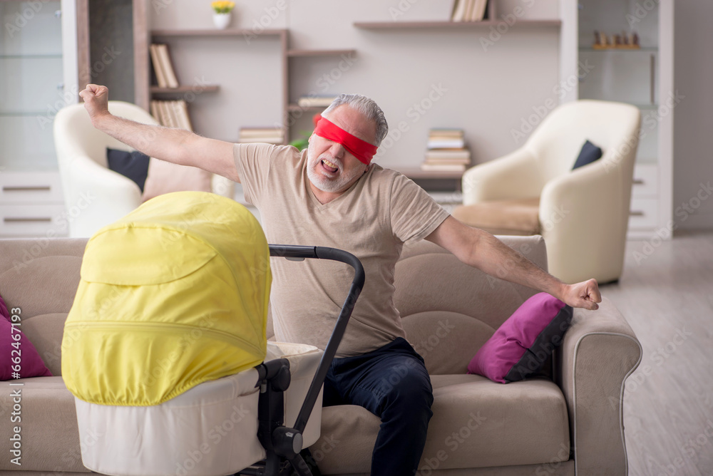 Old man looking after newborn at home Old man looking after newborn at home