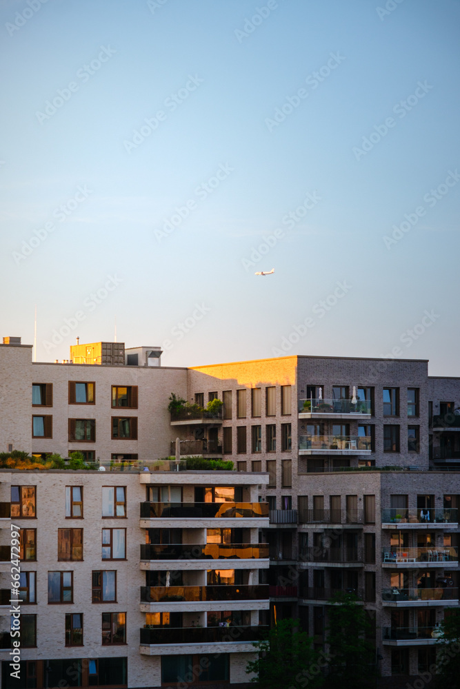 Moderne Wohnungen in Hamburg bei Sonnenuntergang mit Flugzeug