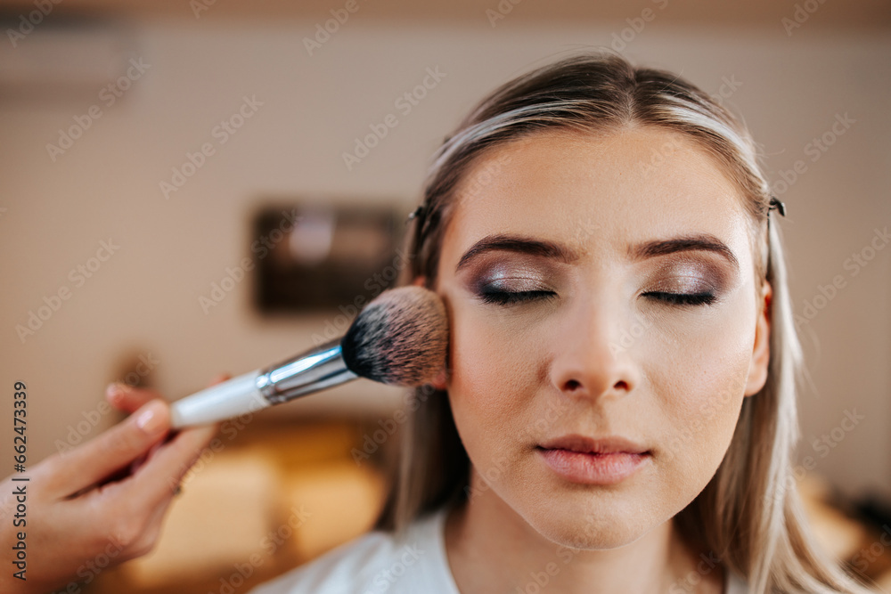 Makeup process. Professional artist applying make up on model face. Close up portrait of beautiful blonde woman in beauty salon. Makeup process. Professional artist applying make up on model face. Close up portrait of beautiful blonde woman in beauty salon.