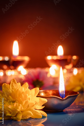 Happy Diwali. Traditional symbols of Indian festival of light. Burning diya oil lamps and flowers on red background.