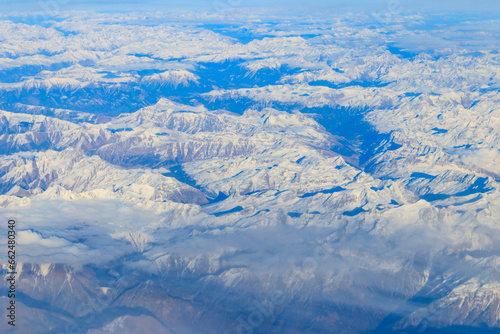 View of the Swiss Alps covered with snow from airplane © olyasolodenko
