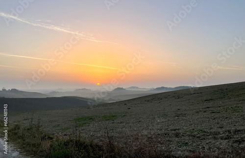 Sunrise in the rolling hills of Tuscany, with some fox on the background
