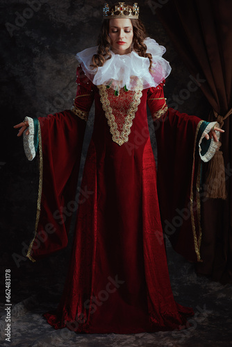Full length portrait of medieval queen in red dress