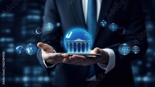 Business man holding in hands tablet pc with glowing bank icon with International business network connection and futuristic interface on dark blue background.