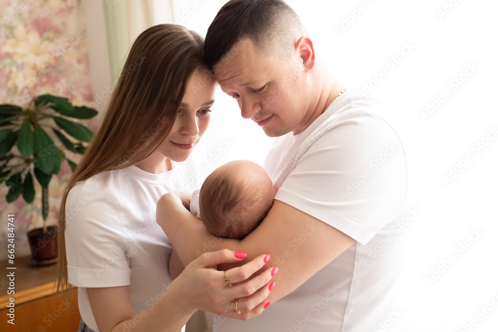 young parents hold the baby in their arms. family lifestyle photo with baby. family concept young parents hold the baby in their arms. family lifestyle photo with baby. family concept