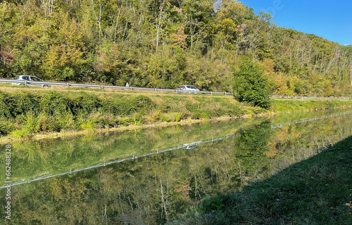Burgundy canal, water reflecting surrounding forest and village