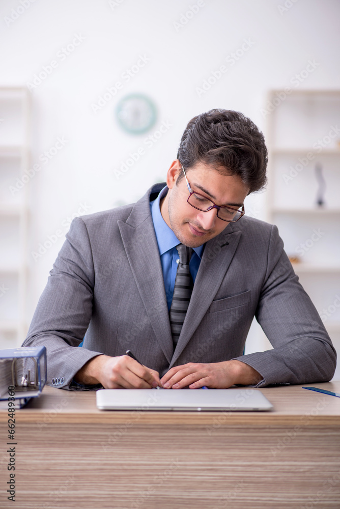 Young male employee working in the office Young male employee working in the office